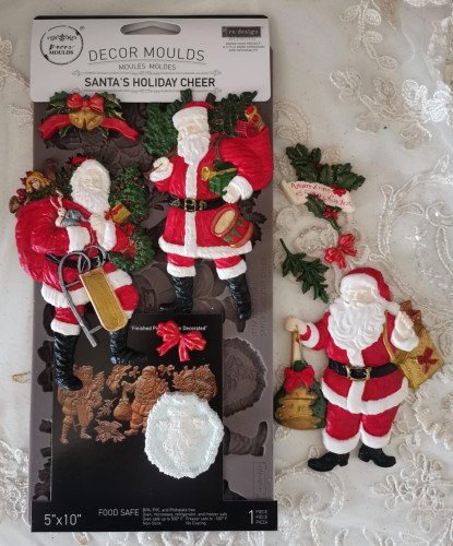 Foremka silikonowa do odlewów o wymiarach  25x13 cm marki Prima wzór Santa's Holiday Cheer. Zawiera motyw  3 postaci Św. Mikołaja z workami pełnych prezentów.  Idealna do decoupage, mixmediów, stylizacji mebli i dekoracji cukierniczych.