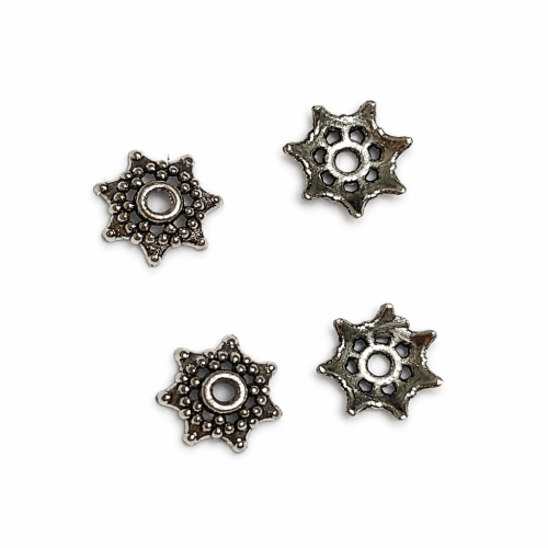 Przekładka ozdobna średnica 10 mm,  wysokość 3mm, kolor srebrny. Wzór tłoczony, filigranowy. Wykonana z metalu nieszlachetnego. Opakowanie 10 sztuk. Sprawdzi się jako nakładka do koralików, wykończenie bombek, jajek i biżuterii.